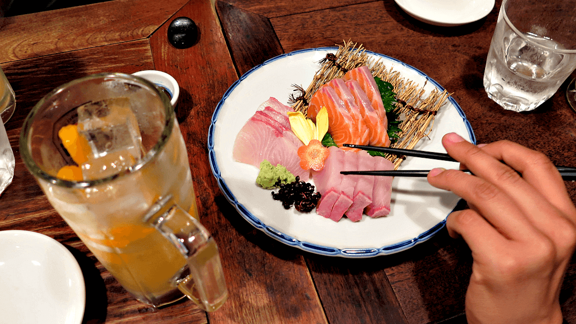 Food and drink, including sashimi, at an authentic izakaya in Kyoto, Japan